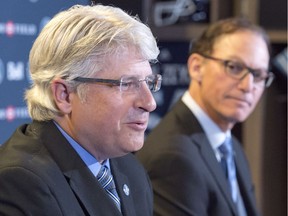 New Toronto Argonauts head coach Marc Trestman, right, listens as new general manager Jim Popp speaks during a media conference in Toronto on Tuesday.