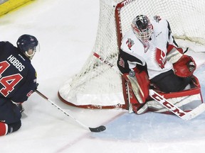 Moose Jaw Warriors goaltender Zach Sawchenko turns aside the Regina Pats' Connor Hobbs at the side of the net en route to recording a shutout on Saturday.