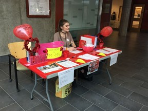 Tracie Leost, U of R student volunteer, sits at the Have a Heart campaign table located in the atrium of Research and Innovation Centre (RIC) at the university.