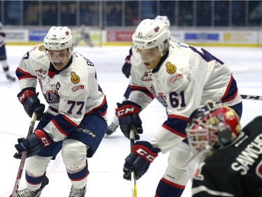 Regina Pats forwards Adam Brooks, 77, and Filip Ahl, 61, go for the rebound near the Moose Jaw Warriors net.