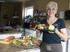 Laurie Wall holds a plate of meatloaf, potatoes and steamed vegetables.