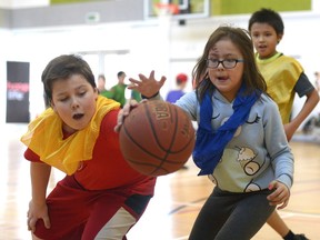 Tyson Davidson, left, and Cavetta Eaglechild, right, take part in the HoopLife Cares basketball camp Wednesday at Seven Stones Community School. The two-day camp, for inner-city youngsters, concluded Wednesday.