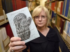 Colleen Murphy, chair of the committee of the Saskatchewan Library Association,  holds up the book The Education of Augie Merasty: A Residential School Memoir written by Auguste Merasty with David Carpenter in Regina.