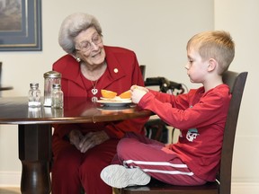 Miriam Wheeler, left, and Colton Ahlquist sit together while Colton has a snack at Orange Tree Living development in Regina.
