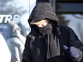 Martina Cain, a teacher who is accused of holding strip basketball drills with a team she coached in La Ronge in the 1980s covers her face as she leaves the Saskatchewan Professional Teachers Regulatory Board office in Regina.