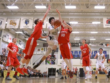 Luther Lions guard Samuel Hardy, 23, lays-up between two Raymond Comets at the Luther Invitational Tournament held at the Luther College High School gym.