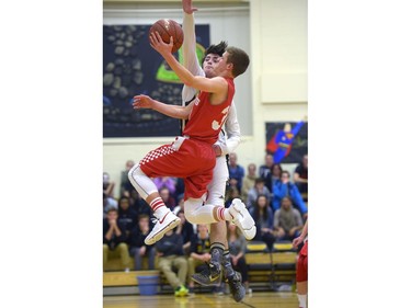 Luther Lions guard Samuel Hardy, 23, jumps to block Raymond Comets guard Chase Bohne's lay-up at the Luther Invitational Tournament held at the Luther College High School gym.