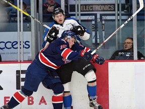 Braydon Buziak of the Regina Pats delivers a hit on Barrett Sheen of the Kootenay Ice.