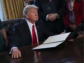 U.S. President Donald Trump signs executive orders in the Oval Office of the White House, in Washington, D.C., on Feb. 3, 2017.