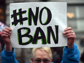 Karen Shore holds up a sign in front of the United States Court of Appeals for the Ninth Circuit in San Francisco, California on February 7, 2017. A federal appeals court heard arguments on Tuesday on whether to lift a nationwide suspension of President Donald Trump's travel ban targeting citizens of seven Muslim-majority countries.