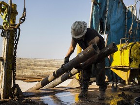 A worker prepares to lift drills by pulley to the main floor of Endeavor Energy Resources LP's Big Dog Drilling Rig 22 in the Permian basin outside of Midland, Texas, U.S., on Friday, Dec. 12, 2014. Of all the booming U.S. oil regions set soaring by a drilling renaissance in shale rock, the Permian and Bakken basins are among the most vulnerable to oil prices that settled at $57.81 a barrel Dec. 12. With enough crude by some counts to exceed the reserves of Saudi Arabia, theyre also the most critical to the future of the U.S. shale boom. Photographer: Brittany Sowacke/Bloomberg