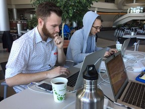 David Crossman (R) and Landon Rohatensky (L) sit at computers during Queen City Hack on Saturday at Innovation Place. The two are working on creating an app or website for Regina Public Library to use during its summer reading contest. PHOTO ASHLEY ROBINSON
