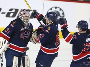 Left to right, Regina Pats goalie Tyler Brown and forwards Filip Ahl and Austin Wagher celebrate after Thursday's 5-1, series-clinching victory over the host Calgary Hitmen.