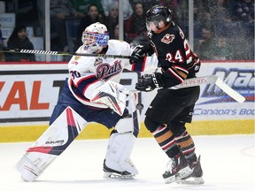 Jordan Hollett, 30, of the Regina Pats and Luke Coleman of the Calgary Hitmen battle for a loose puck in open ice on March 4, 2017 at the Brandt Centre. Photo by Keith Hershmiller, Hershmiller Photography.