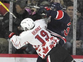 Moose Jaw Warriors forward Brayden Burke lays a hit on Regina Pats defenceman Dawson Davidson during WHL action at Mosaic Place on Saturday. Photo by Randy Palmer, Moose Jaw Times-Herald.