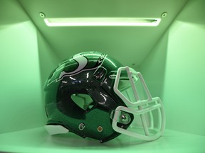 A green-lit compartment holds each player's helmet in the locker room.