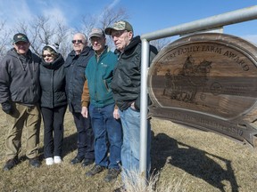 Siblings Alvin, Selena (Rodger), Harvey, Maurice, and Leo Hartness, from left, stand by the Century Family Farm Award at the Hartness farm. Their father Walter established the farm in 1910, and Maurice continues to farm the original settlement today.