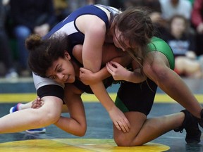 Aliyah Lerat of Martin, bottom, faces Robyn Kirwan of Miller in a 64-kilogram female match Friday at the Regina High Schools Athletic Association wrestling championships, held at Campbell Collegiate.