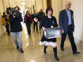 Jackie Christianson, chair of the CUPE education workers steering committee, and Tom Graham, president of CUPE Saskatchewan, deliver a box of postcards from citizens concerned about government funding cuts to education at the Legislative Building.