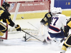 Regina Pats captain Adam Brooks knocks a rebound past Brandon Wheat Kings goalie Travis Child during the first period of Friday's WHL game at the Brandt Centre.