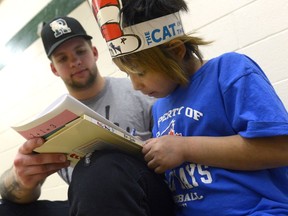 Grey McKen, left, spends some time reading and drawing with Serenity Semaganis.