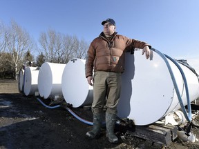 Dale Heenan, a grain farmer southwest of Regina stands beside his fuel tanks on his farm.