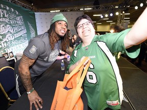 Riders receiver Naaman Roosevelt (left) poses with a fan during CFL Week.