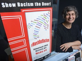 Rhonda Rosenberg, executive director of the Multicultural Council of Saskatchewan, looks at the organization's latest educational poster at her office.