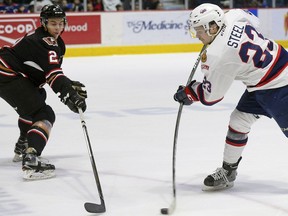 Regina Pats centre Sam Steel leans into a shot against Calgary Hitmen defencemen Jake Bean during WHL playoff action at the Brandt Centre on Saturday.