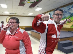 Darlene MacQuarrie, director of programming for Special Olympics Saskatchewan, bites on a silver medal while left-winger Chris Anderson celebrates the Saskatchewan floor hockey team's victory at the Austrian Club. The team recently returned from the Special Olympics World Winter Games in Austria.