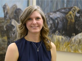 Carleen Ross stands in front of her exhibition "From Sea to Sea" at the RCMP Heritage Centre. The paintings feature bison, an animal that has strong ties to the RCMP.