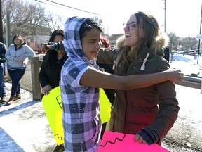 Tristianna Geddes-Goforth, left, and Kaeli Eurich, right, hug during Spread Love, a family event at Carmichael Outreach. Food, music and free hugs were available.