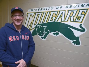 University of Regina Cougars women's basketball head coach Dave Taylor models some Boston Red Sox gear outside his office.