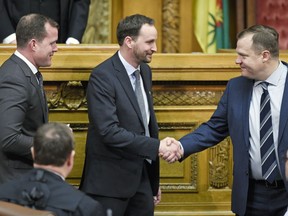 Trent Wotherspoon, left, interim leader of the Saskatchewan NDP, looks on as Warren McCall, right,NDP MLA Regina Elphinstone-Centre shakes the hand of Saskatoon-Meewasin MLA Ryan Meili, middle, after being sworn in at the Legislative Building in Regina.