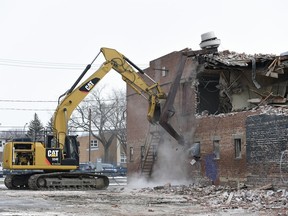 A track hoe from Davies Excavating Ltd. knocked down the top floor of the Travellers Building on the 1800 block of Broad Street.