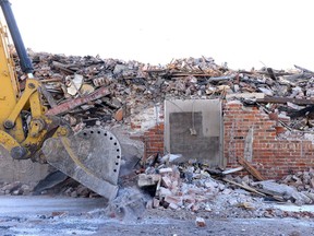 A trackhoe pushes rubble next to the Travellers Building on March 9, 2017.