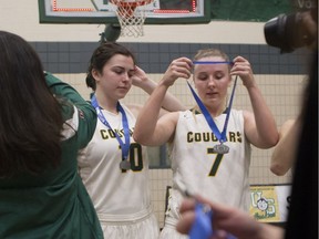 University of Regina Cougars players Ainsley MacIntyre (10) and Sara Hubenig (7) accept their silver medals Saturday after the host University of Saskatchewan Huskies won the Canada West women's basketball championship.