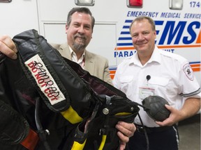 Glen Perchie, executive director of emergency and EMS with the Regina Qu'Appelle Health Region, and dispatcher Jamie Knapman, right, hold "shock pants" at EMS central headquarters. The Pneumatic Anti-Shock Garment, no longer in use, was a way paramedics could raise the blood pressure of a patient.