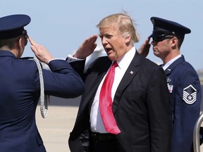President Donald Trump salutes the U.S. Air Force security detail at Orlando International Airport during his arrival to  visit to St. Andrew Catholic School, in Orlando, Fla., Friday, March 3, 2017.
