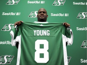 Vince Young, a former quarterback with the NFL's Philadelphia Eagles and Tennessee Titans, holds up a jersey after signing with the CFL's Saskatchewan Roughriders at Mosaic Stadium in Regina Thursday, March 9, 2017.