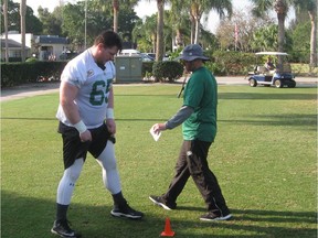 Dillon Guy (left) receives instruction from offensive line coach Stephen Sorrells during the Saskatchewan Roughriders mini-camp at Vero Beach, Fla., on Thursday.