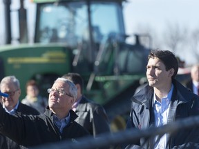 Rod Lewis, left, shows Prime Minister Justin Trudeau around the Lewis Family Farm in Gray, Sask. on April 27, 2017.