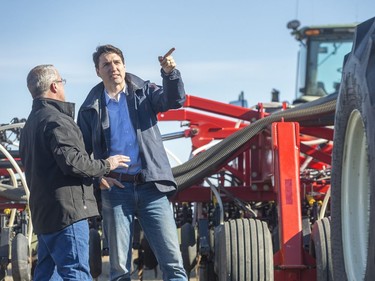 Rod Lewis, left, shows Prime Minister Justin Trudeau around his air seeder at the Lewis family farm.