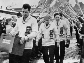 The Ernie Richardson curling team returns to Regina from Scotland with the Scotch Cup, awarded to the world men's curling champion. Ernie Richardson is in the front, followed by Arnold, Sam and Wes.