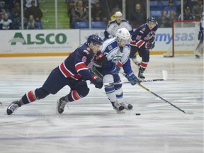 Tyler Steenbergen of the Swift Current Broncos tries to keep the puck away from Regina Pats defenceman Chase Harrison during Saturday's WHL playoff game in Swift Current. Steven Mah, Southwest Booster.