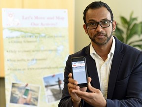 Dr. Tarun Katapally holds up a smartphone with the app he helped create to collect data on physical activity.