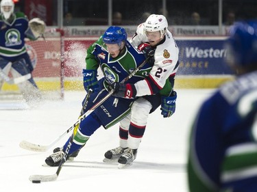 Swift Current Broncos defence Colby Sissons #2 recovers a loose puck while Regina Pats forward Austin Wagner #27 pressures him during the first period of the seventh game of the series at the Brandt Centre.