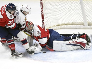 Lethbridge Hurricanes Brennan Menell, left, and goalie Stuart Skinner stop the shot of Regina Pats Nick Henry in WHL playoff action at the Brandt Centre in Regina.