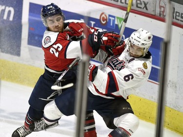 Lethbridge Hurricanes  Zane Franklin, left, checks Regina Pats Chase Harrison in WHL playoff action at the Brandt Centre in Regina.