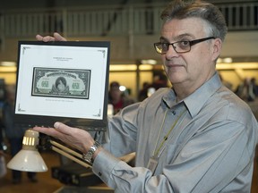 George Manz, president of the Regina Coin Club, holds up a Canadian 1917 $1 specimen note that depicts Princess Patricia, the granddaughter of Queen Victoria, at the coin show at the Turvey Centre in Regina.